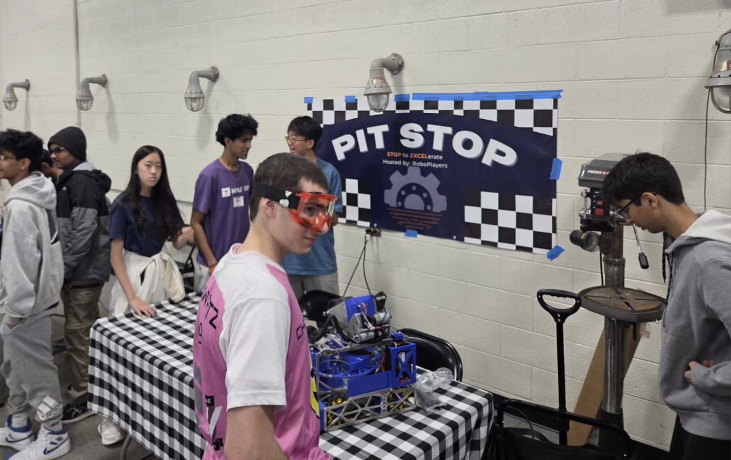RoboPlayers PitStop event with team members helping younger FTC teams with their robot
