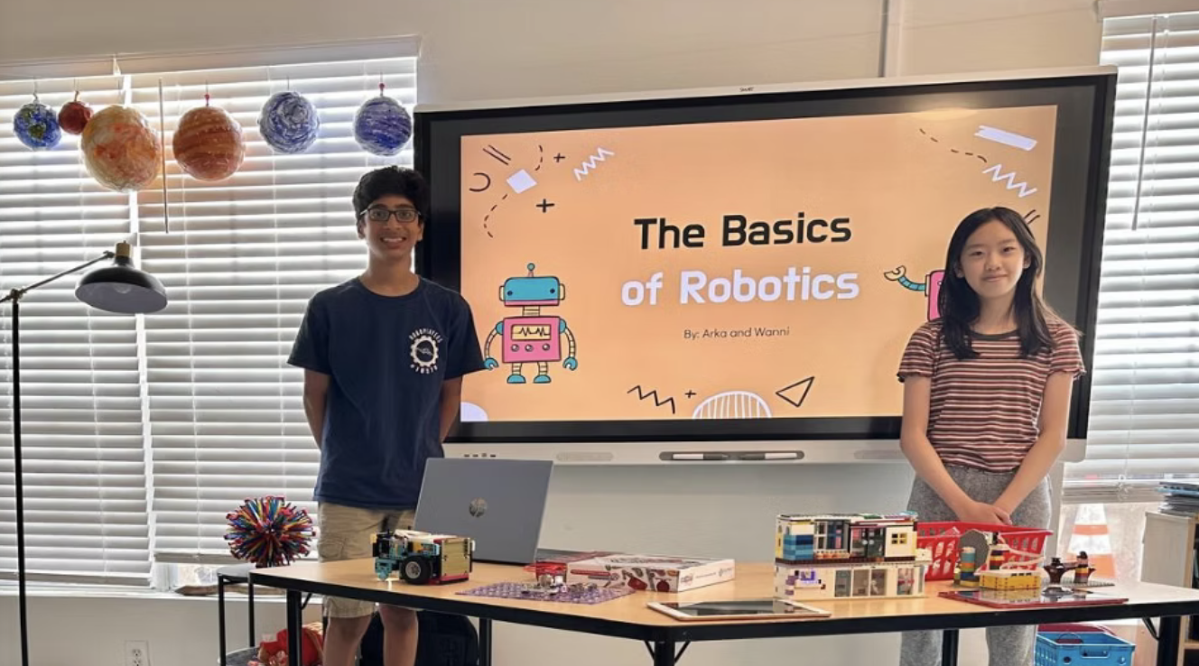 Two RoboPlayers team members presenting The Basics of Robotics to younger students